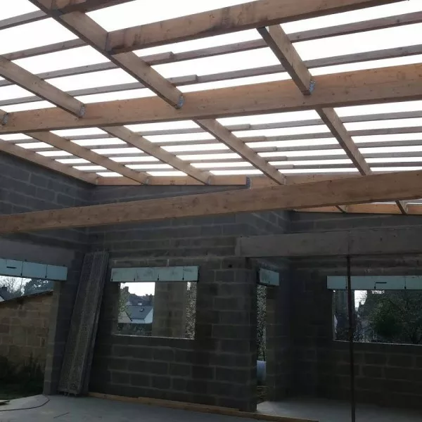 Charpente traditionnelle en cours de pose sur une maison en parpaing