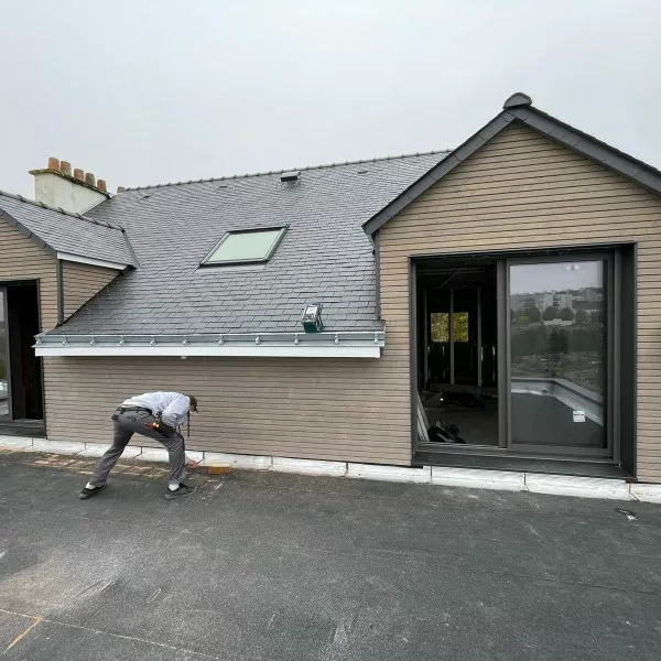 Extension avec baie coulissante aluminium, toiture ardoise et fenêtre de toit