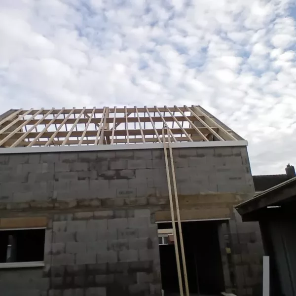 Charpente bois vue de l'extérieur, pignon en parpaing, chantier de décembre 2024