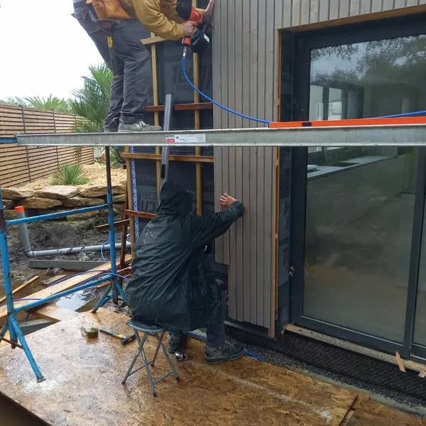 Pose d'un bardage bois vertical autour d'une baie aluminium